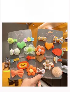 Détail de pinces à cheveux fait main avec fleurs et cœurs en tissu pour filles
