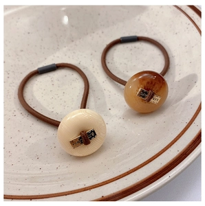 Detail of high-elastic hair ties with marble pattern pendants and Love Days metal pieces
