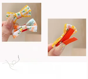 Vue détaillée des barrettes en tissu avec motifs floraux oranges et jaunes