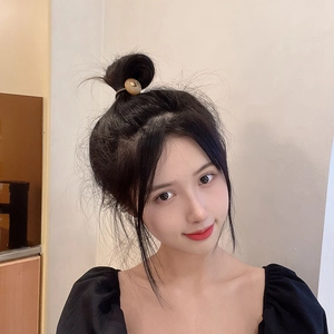 Brown high-elastic hair tie with amber round button accessory on a bun hairstyle
