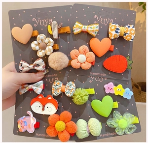 Détail de pinces à cheveux faites main avec fleurs en tissu et animaux pour petites filles