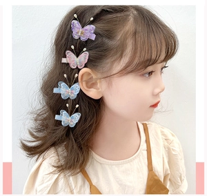 Gros plan d'une fille portant des barrettes papillon brodées avec perles blanches