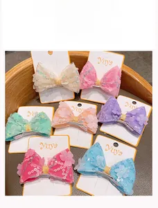 Détail de barrettes à nœuds colorés avec paillettes et fleurs 3D pour petites filles