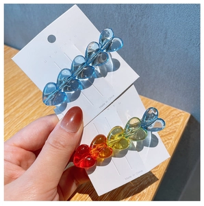 Close-up of heart-shaped gradient candy color hair clips on white card display