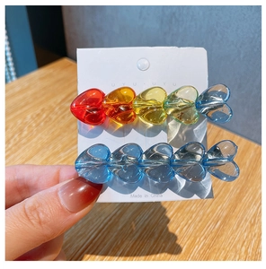 Detail of candy-colored acrylic heart beads hair clips on white card holder packaging