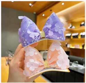 Détail de grandes pinces à cheveux en résille avec paillettes et fleurs 3D