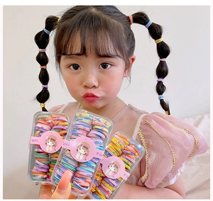 Trois boîtes d'élastiques à cheveux colorés à haute élasticité pour enfants montrées