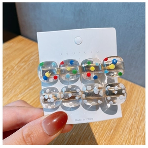 Detail of transparent acrylic hair clips with colorful polka dots on jewelry card