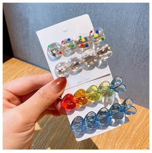 Set of four colorful acrylic heart and polka dot duckbill hair clips with gold metal base