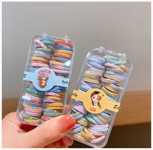 Détail d'élastiques à cheveux colorés avec motifs d'étoiles dans une boîte transparente