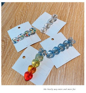 Set of four resin duckbill hair clips with polka dots and heart shapes on wood background