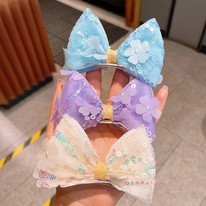 Trois barrettes à nœuds en tulle à paillettes bleu pastel, violet et crème