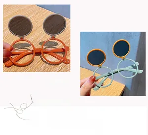 Dettaglio degli occhiali da sole rotondi a ribalta per bambini in arancione e blu con lenti scure