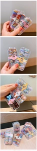 Détail de mini élastiques à cheveux colorés pour enfants dans une boîte de rangement