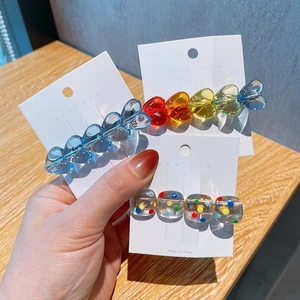 Three colorful candy heart and polka dot hair clips on a white display card
