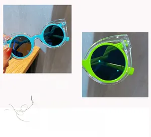 Detail view of round frame kids sunglasses with light blue and green inner frame layers