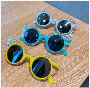 Three pairs of kids cat-eye sunglasses with dual-frame design on a light wood background