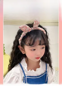 Close-up of pink floral bow headband on a little girl featuring soft fabric detail