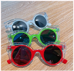 Close-up of children's colorful round polarized sunglasses in red, green and white colors