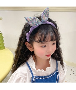 Detail of purple floral rabbit ear headband on girl featuring soft fabric texture