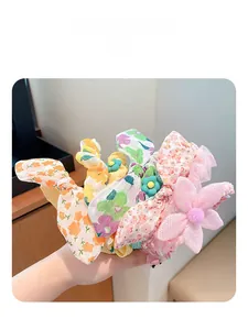 Close-up of colorful floral fabric hair scrunchies with cute bunny ears and 3D flower details