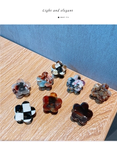 Detail view of assorted floral acetate hair claws in checkered and marble patterns