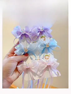 Detail of six-piece kids bow hair clip set with organza ribbon and sequin bunny charms