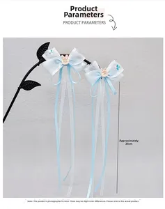 Detail of light blue bow hair clips with long tassels and rabbit charms, 25cm length