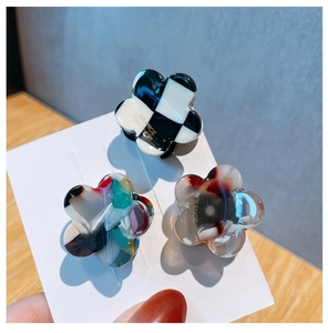 Close-up of floral hair claws in checkered, marble, and amber acetate textures