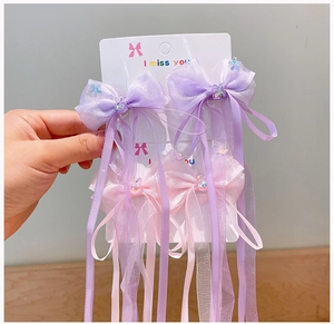 Detail of organza bow hair clips with long ribbons and cute resin bear accents