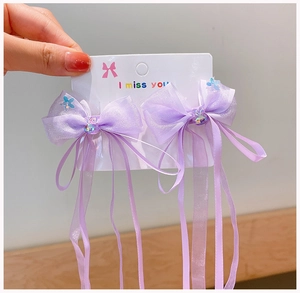 Detail of purple chiffon bow hair clips with long tassels and decorative center beads