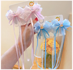 Detail of pink and blue chiffon bow hair clips with long streamers and rabbit gemstones