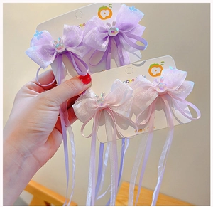 Detail of organza bow hairpins with ribbon tassels and cute rabbit charm for girls