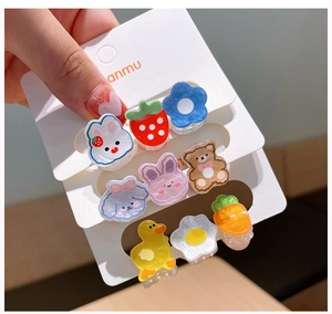 Détail de mini barrettes en acrylique avec motifs de fleurs et oursons nacrés