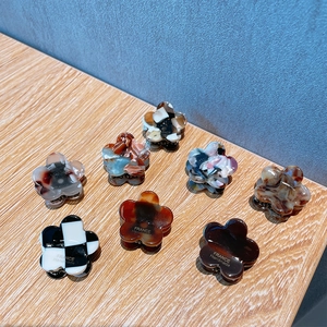 Floral hair claw clips with checkered and marble patterns on a wooden surface