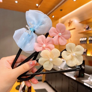 Détail de chignon fleur en organza avec perles et nœud couronne orné de strass