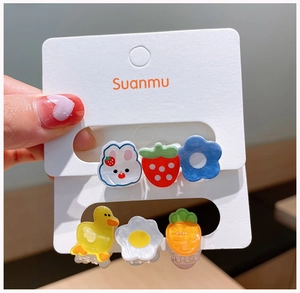 Gros plan de 6 mini barrettes en résine aux motifs de lapin et fleurs sur carte