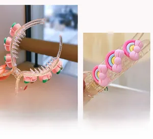 Dettaglio di mini mollette per capelli con fragola rosa e fiocco arcobaleno colorato