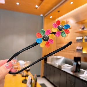 Détail de l'accessoire chignon avec fleurs au crochet colorées et bouton à pois décoratif