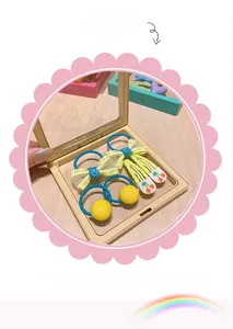 Close-up of kids hair accessories set with yellow bow and cherry clips in a box