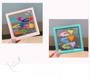 Close-up of colorful acrylic hair clips with heart and bead designs in clear display boxes