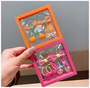 Close-up of colorful bow hair ties and cherry hair clips in transparent PE display boxes