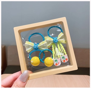 Detail of 6-piece blue and yellow hair accessories set with polka dots and cherry clips