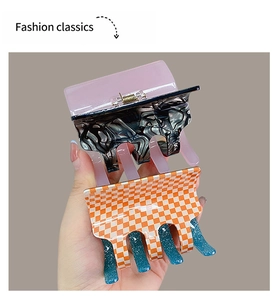 Detail of pink marble and orange checkered acetate hair claw clips with metal spring