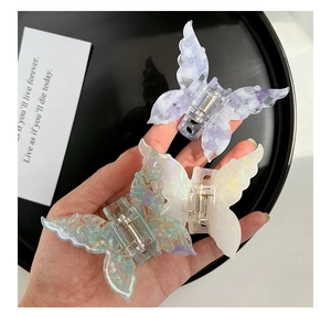 Detailed view of three marble pattern butterfly hair claws in purple and green hues