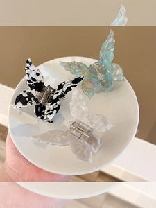 Detailed set of three acetate butterfly hair clips in cow print and gradient pastel colors