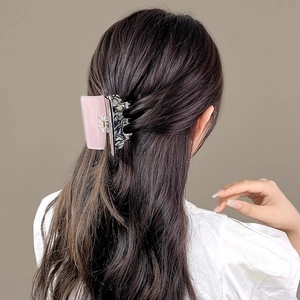 Detail of a large rectangular acetic hair claw showing pink and marble color splicing on hair