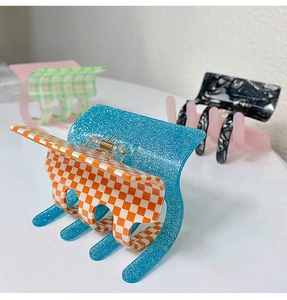 Detail view of colorful acetate claw clips with checkered and marble patterns for hair
