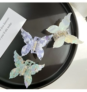 Detailed view of three 3D butterfly hair claws in marble and floral acetate patterns
