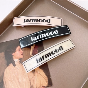 French vintage larmood hair clips set in pink, black, and white on a metal tray